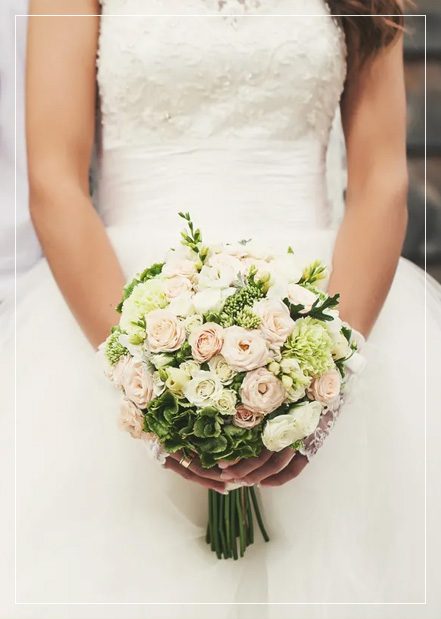 A bride holding her bouquet of flowers in her hands.